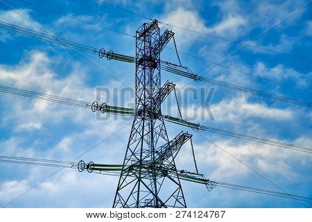 A Transmission Tower Or Electricity Pylon With Blue Sky. It Is A Tall Structure, Usually A Steel Lat
