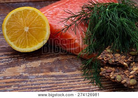 Fresh Salmon Closeup On Wooden Background With Lemon And Dill.