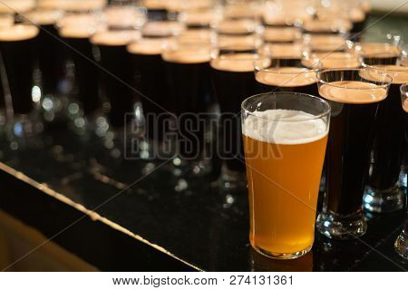 Beer Glasses With Dark Beer Are On The Bar Counter