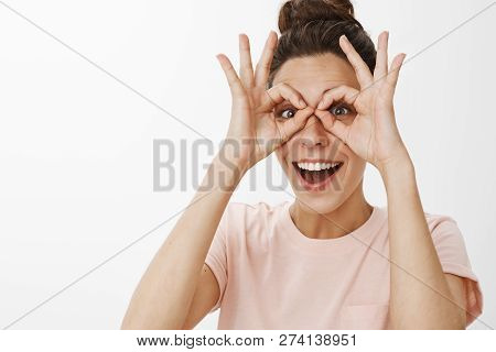 Cheerful Funny And Playful Young Creative Woman Showing Glasses With Orbs Over Eyes Having Fun Smili