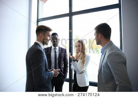 Young Modern Colleagues In Smart Casual Wear Having A Brainstorm Meeting While Standing In The Creat