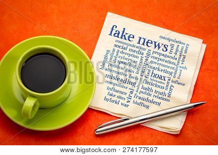 fake news word cloud on a napkin with a cup of espresso coffee