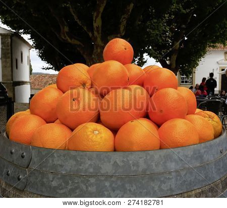A Pile Of Large Ripe Valencia Oranges On A Barrell