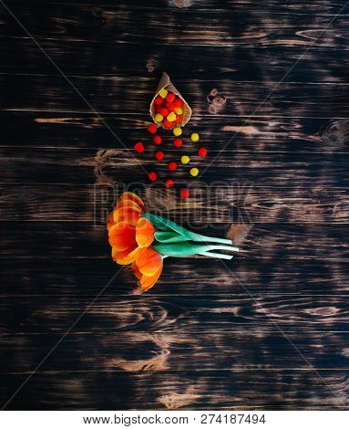 Tulips With Sweets In A Waffle Horn On A Wooden Background.