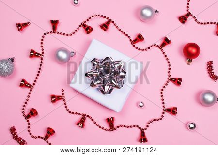White Gift Box Decorated With Shuny Bow, Silver And Red Decoration Accessories On Pink Pastel Backgr