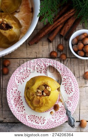 Baked Apples With Raisins, Hazelnuts And Cinnamon On Wooden Background. Rustic Style.