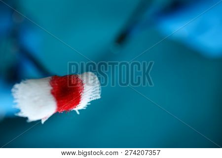 Surgeon In Sterile Uniform Arms Holding And Passing To Colleague Tools With Bio Material Wad Closeup