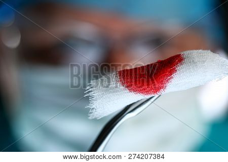Surgeon In Sterile Uniform Arms Holding And Passing To Colleague Tools With Bio Material Wad Closeup