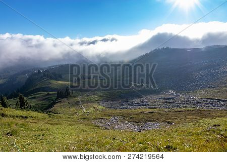 Sun Shining On Mountaion Meadow Amd Fog