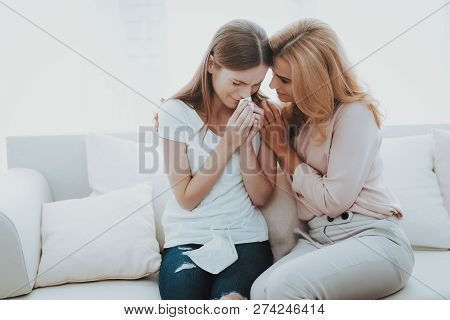 Woman Comforts Unhappy Teenage Daughter At Home. Sitting At Home On Couch. Girl With Problem. Confli