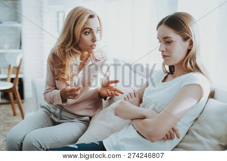 Quarrel Between Mother And Daughter In White Room. Emotional Discussion. Sitting On Couch. Conflict 