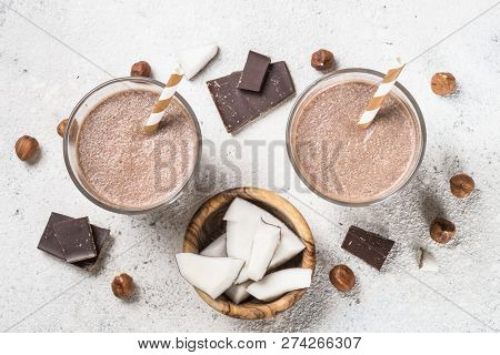 Chocolate Coconut Hazelnut Milkshake Or Smoothie In Two Glasses On White Table. Top View.