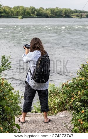 Lasalle, Quebec - August 15, 2018 - Vertical Landscape A Woman Taking Pictures By The Shore, On A Su