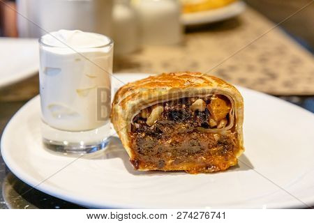Strudel With Prunes, Dried Apricots And Nuts Lying On A Plate.