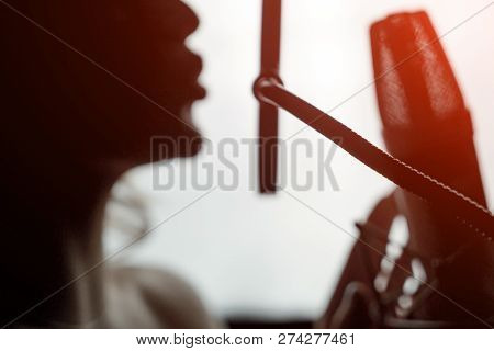 Sexy Silhouette Female Profile With Pretty Face And Bare Shoulder Near Microphone On Studio Backgrou