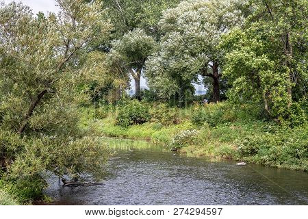 Lasalle, Quebec - August 15, 2018 - Horizontal Landscape Two People Relaxing On A Park Bench Surroun