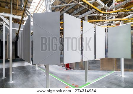 Powder Coating Line. Metal Panels Are Suspended On An Overhead Conveyor Line. Painting Products In A
