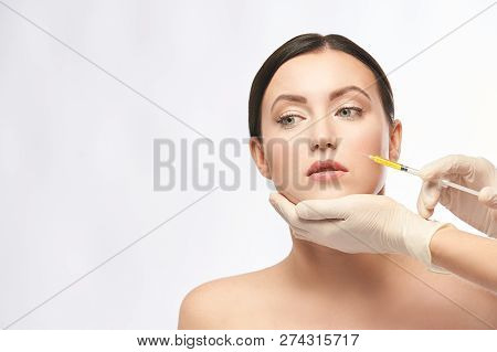 Face Needle Injection. Young Woman Cosmetology Procedure. Doctor Gloves