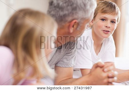 Father having a discussion with his children in a bedroom