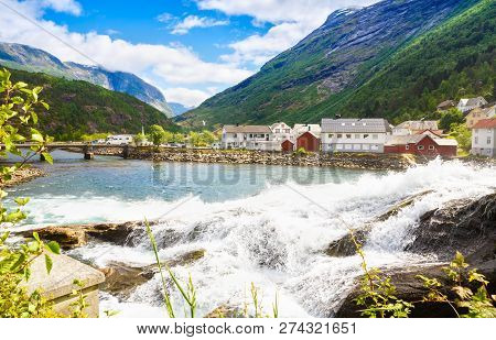 Landscape With Mountains, Houses, Bridge And River In Hellesylt, Norway.