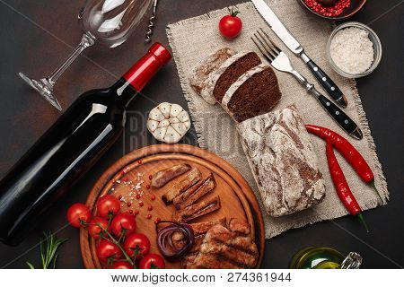 Sliced Grilled Pork Steaks With Bottle Of Wine, Wine Glass, Corkscrew, Knife, Fork, Black Bread, Che