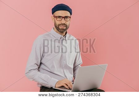 Male Graphic Designer Thinks About Creative Ideas, Reads News On Internet Website, Uses Moderm Lapto