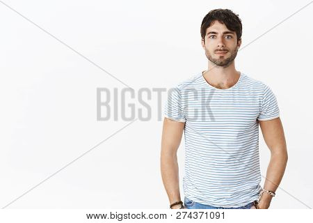 Portrait Of Masculine Attractive European Man With Blue Eyes And Brsitle, Wavy Hair Smirking Casuall