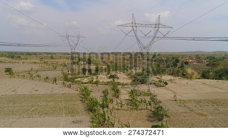 Electricity Pylons Bearing Power Supply Across Rural Landscape. Aerial View Power Pylons And High Vo
