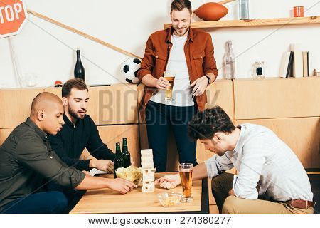 Multiethnic Friends Playing Blocks Wood Game In Cafe
