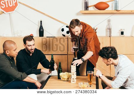 Multiethnic Friends Playing Blocks Wood Game In Cafe