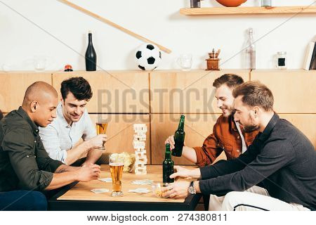 Multicultural Men Playing Cards While Spending Time Together In Cafe
