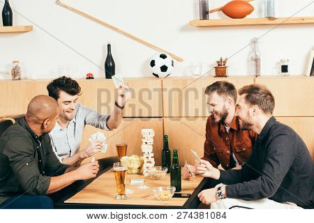 Multicultural Men Playing Cards While Spending Time Together In Cafe