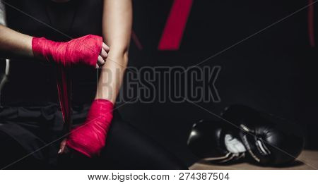 Girl In Uniform On Black Background. Close Up Of Female Hands Red And Pink Bandages For Hard Sports,