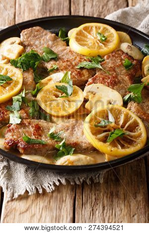 Italian Veal Scaloppini With Mushrooms And Lemons In A Sauce Close-up In A Frying Pan. Vertical