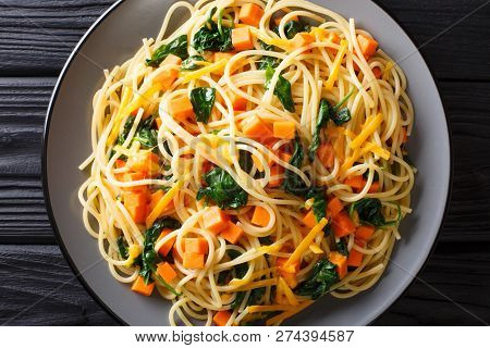 Low-calorie Lunch Of Spaghetti With Pumpkin, Spinach And Cheddar Cheese Close-up On A Plate. Horizon