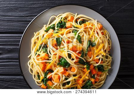 Organic Spaghetti Meal With Pumpkin, Spinach And Cheddar Cheese Close-up On A Plate. Horizontal Top