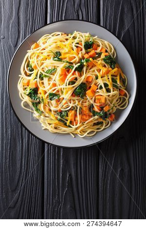 Italian Vegetarian Spaghetti With Pumpkin, Spinach And Cheddar Cheese Close-up On A Plate. Vertical