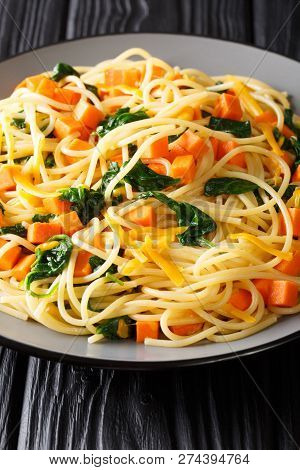 Italian Vegetarian Spaghetti With Pumpkin, Spinach And Cheddar Cheese Close-up On A Plate. Vertical