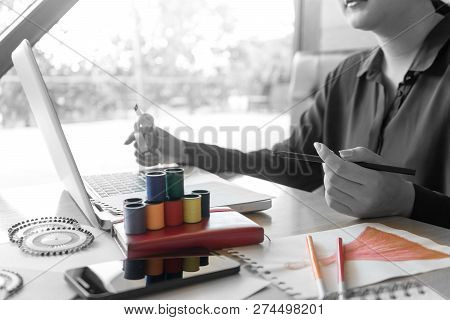 Professional Fashion Designer Working And Drawing Sketches On The Table