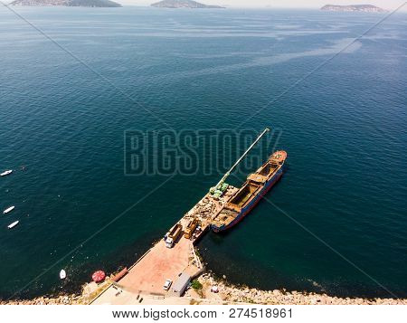 Aerial Drone View Of Old Garbage Scow Vessel Ship With Crane In The Port