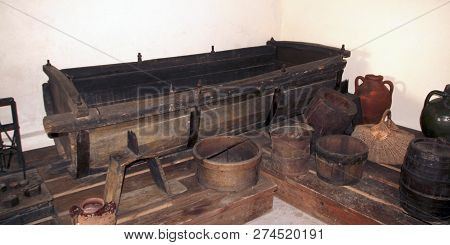 A Wooden Vat For Grape-stomping, Buckets And Other Antique Household Items In The Basement Of A Trad
