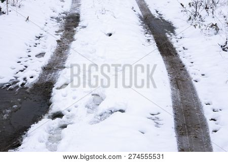 The Road Is Covered With White Snow. Slippy Road. Close Up Of A Cars Tires On A Snowy Road