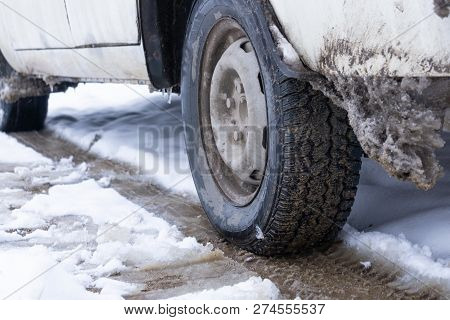 The Road Is Covered With White Snow. Slippy Road. Close Up Of A Cars Tires On A Snowy Road
