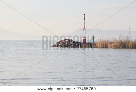 A Man On The Pier At The Lake Balaton In Winter