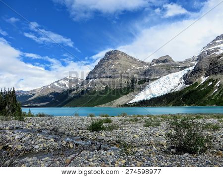 An Open Valley Of Rocks And Creeks Leading Towards The Teal Waters Of Berg Lake And Mount Robson Gla