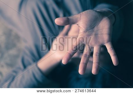 The Palm Of A Female Hand Giving The Signal To Stop. The Dark, Moody Image Is A Concept Of A Woman B