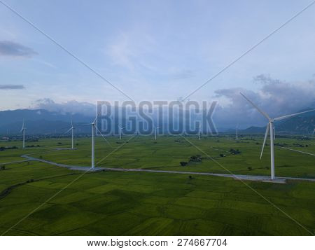 Wind Turbine Farm Or Windmill On Blue Sky. Turbine Green Energy Electricity Or Wind Turbine In A Gre