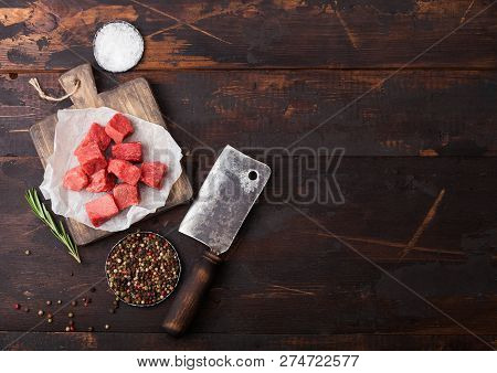 Raw Lean Diced Casserole Beef Pork Steak On Chopping Board With Vintage Meat Hatchet On Wooden Backg