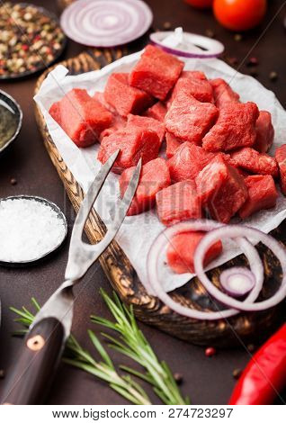 Raw Lean Diced Casserole Beef Pork Steak With Vintage Meat Hatchet And Fork On Brown Background. Sal