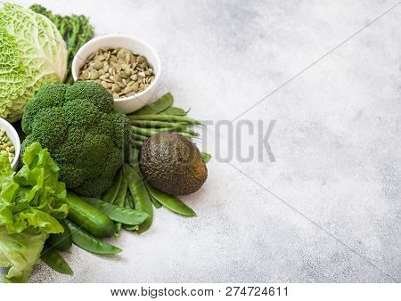 Assorted Green Toned Raw Organic Vegetables On White Stone Background. Avocado, Cabbage, Broccoli, C